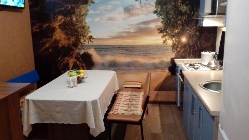 a table in a kitchen with a painting of the ocean at Hostel Viator in Almaty