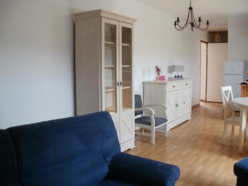 un salon avec un canapé bleu et une salle à manger dans l'établissement la ferme fleurie, à Echinghen