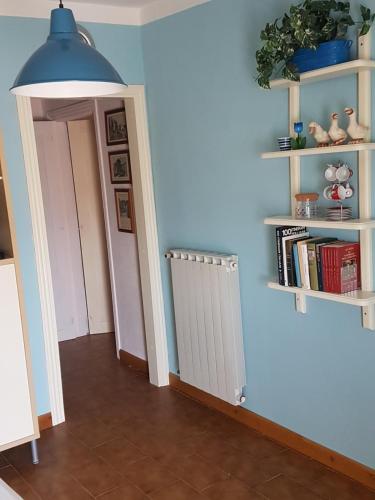 a hallway with a blue wall with shelves and a radiator at Accasamia Terricciola in Terricciola