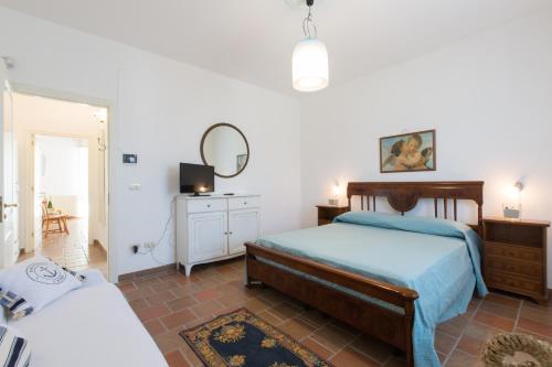 - une chambre avec un lit, une commode et un miroir dans l'établissement Villa Milù, à Torre San Giovanni
