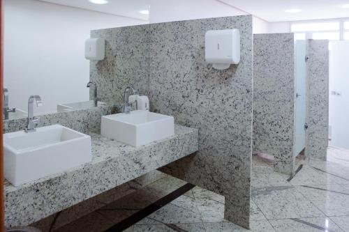 a bathroom with two sinks and a mirror at JVA Fenix Hotel in Uberlândia