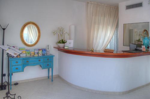 Habitación con mesa azul y espejo. en Hotel Noris, en Finale Ligure