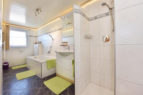 ein Bad mit einer Badewanne, einem Waschbecken und einer Dusche in der Unterkunft Bio-Bauernhof Heidegger in Möggers