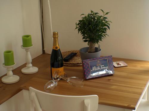 a table with a bottle of wine and a book at Holmdale Holiday Cottages in Rye
