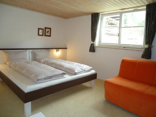 a bedroom with two beds and a window and a chair at Appartement Pleikner in Neukirchen am Großvenediger