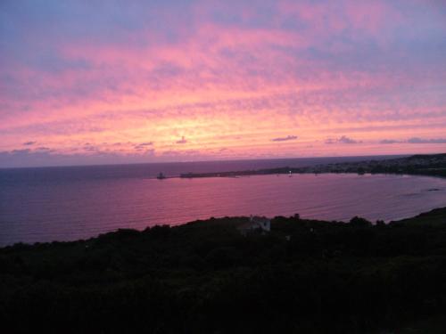 a sunset over a body of water at Charly Point Villa in Methoni