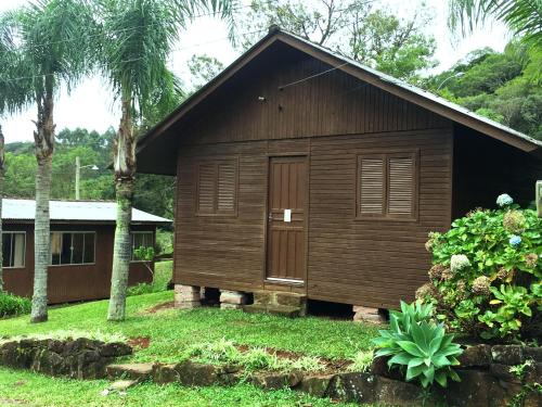 a small wooden building with a door in a yard at Pousada Esperança in Osório