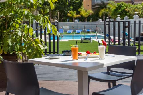 a white table with chairs and drinks on it at Veramar Aparthotel in Fuengirola