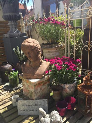 a statue sitting next to a bunch of flowers at B&B Con Ampère in Bruges