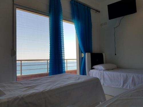 a bedroom with a window with a view of the ocean at Sunset Hotel Roza in Vlorë