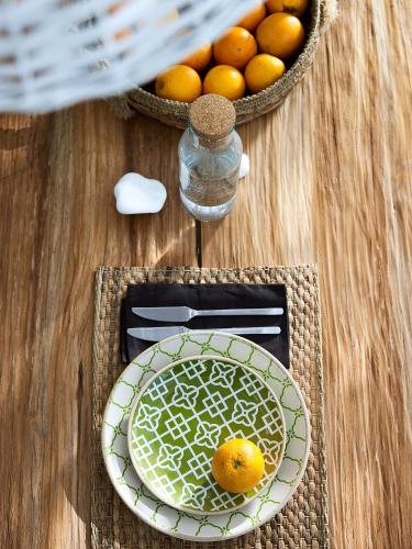 a table with a plate and a basket of oranges at Delmar Apartments & Suites Milos - Delmar Collection in Pollonia