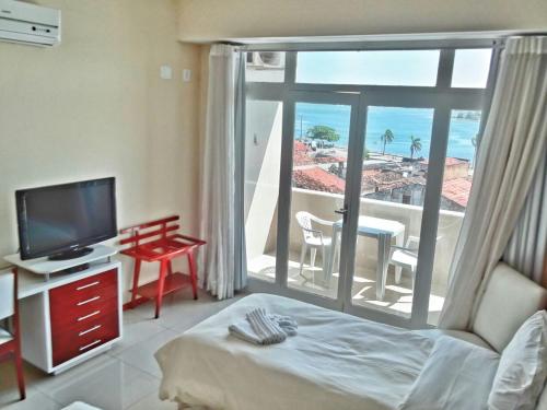 a living room with a television and a view of the ocean at Hotel São Francisco in Penedo