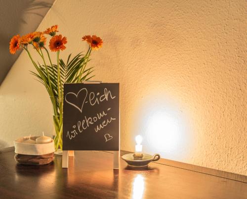 a table with a candle and a vase with flowers at Borner Schlafwandler in Born