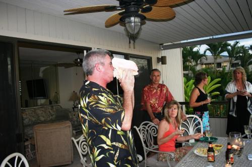 a man drinking water from a bottle while a group of people at Wailea Sunset Condo - Ekolu #607 in Wailea