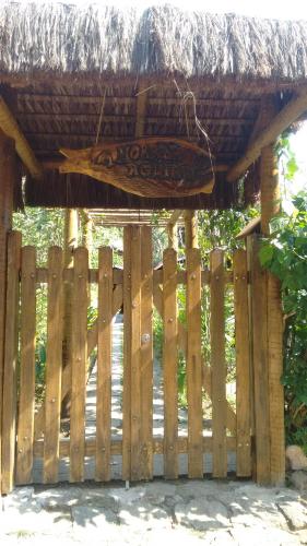 a wooden fence with a thatch roof over a gate at Kitnet e Suite Morada Aguiar - Chalé in Abraão