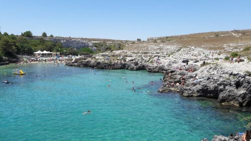 a group of people swimming in a river with rocks at la casa nell'acqua in Otranto