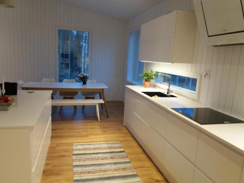 ロヴァニエミにあるVilla Ylikyläのキッチン(白いキャビネット、テーブル付)、ダイニングルーム
