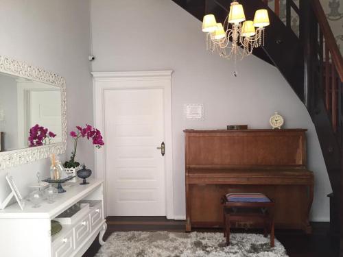 a living room with a piano and a mirror at Chalé Boutique Blumenhof in Blumenau