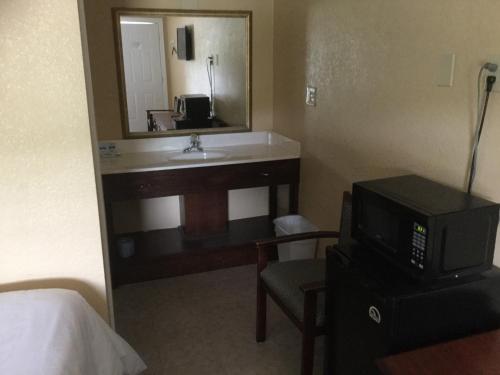 a hotel room with a sink and a mirror at Murphy Motel in Letitia