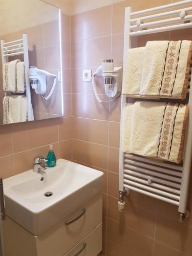 a bathroom with a sink and a mirror and towels at Guesthouse Galimar in Crikvenica