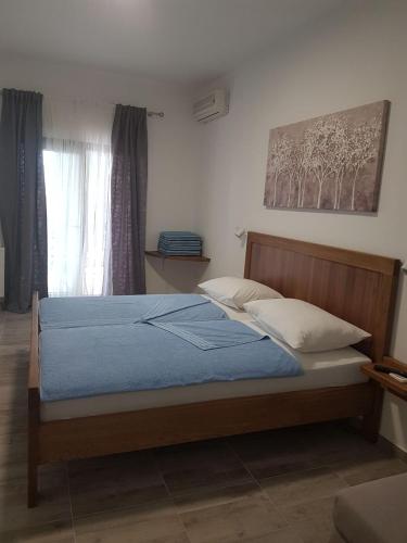 a bedroom with a bed with blue sheets and a window at Guesthouse Galimar in Crikvenica