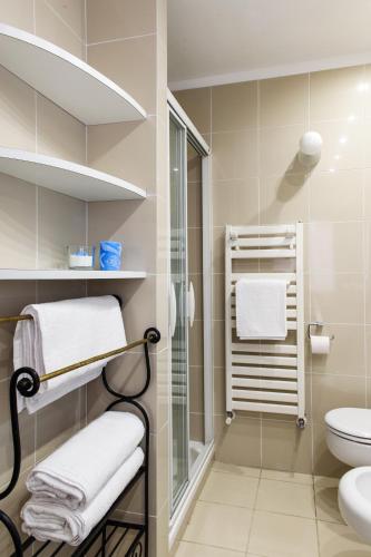a bathroom with a shower and a toilet and towels at Lora Center apartment, near the lake with air conditioner in Como