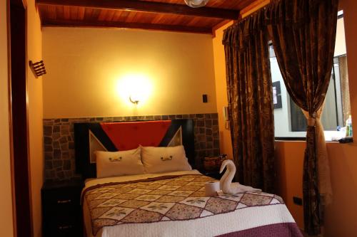 una camera da letto con un letto a cigno sopra di Paradisse a Huacho
