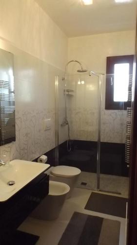 een badkamer met een douche, een toilet en een wastafel bij Villetta Del Salento Exclusive B&B in Gallipoli