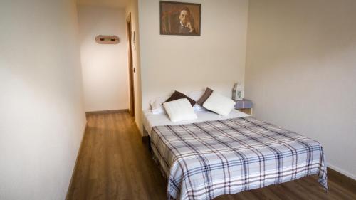 a hotel room with a bed with a plaid blanket at Hotel La Gerencia in Checa