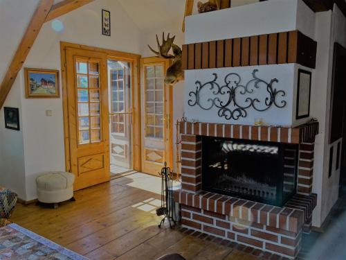 a living room with a brick fireplace and wooden floors at Franz Rudolf in Bad Aussee