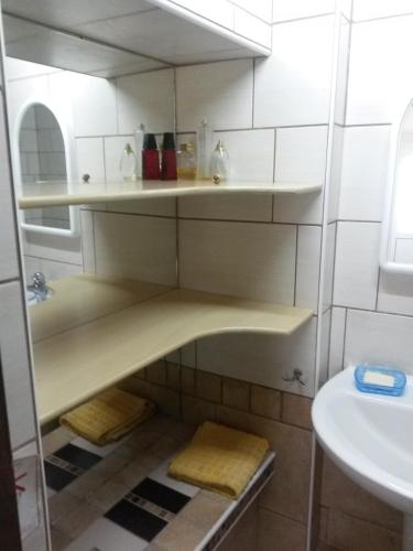 a bathroom with white shelves and a sink at Sea&Stone Apartment in Skala Sotiros