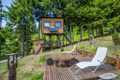 a tree house with a table and two chairs at Tree House Gorski Lazi in Tršće