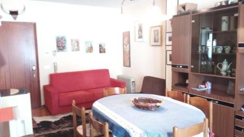 a living room with a table and a red couch at Villaggio Bianco in San Giacomo