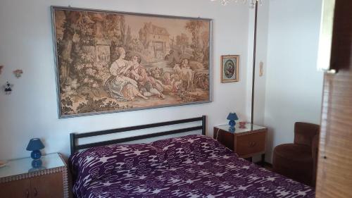 1 dormitorio con una pintura colgada sobre una cama en Villaggio Bianco en San Giacomo