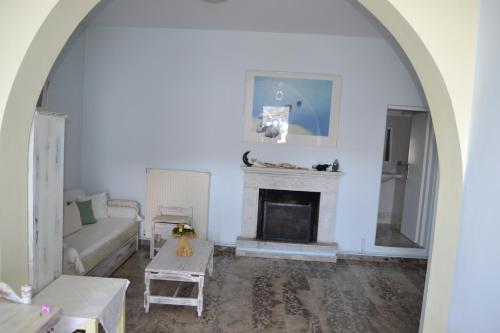 a living room with a couch and a fireplace at Studio Ioanna Tinos in Kionia