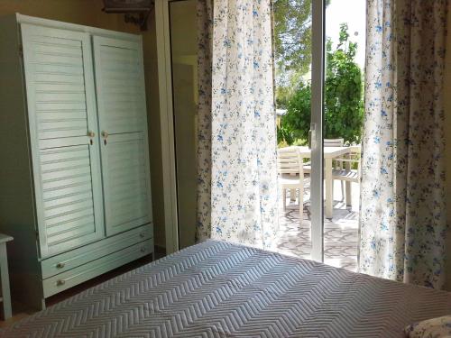a bedroom with a bed and a window with a patio at Marinos Apartments in Lassi