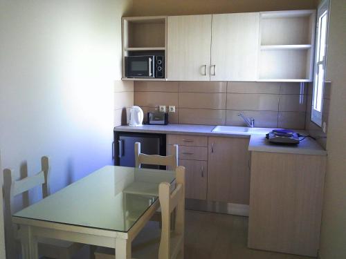 a small kitchen with a table and a microwave at Marinos Apartments in Lassi