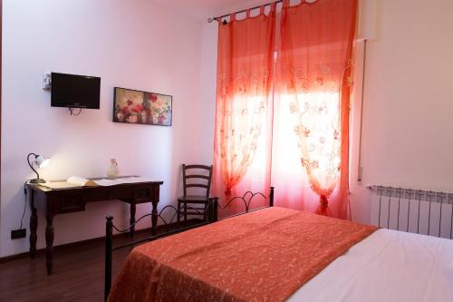 a bedroom with a bed and a desk and a window at Le Cinque Novelle in Agrigento
