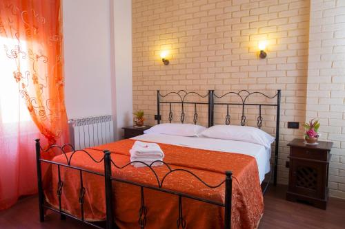 a bedroom with a large bed with an orange blanket at Le Cinque Novelle in Agrigento