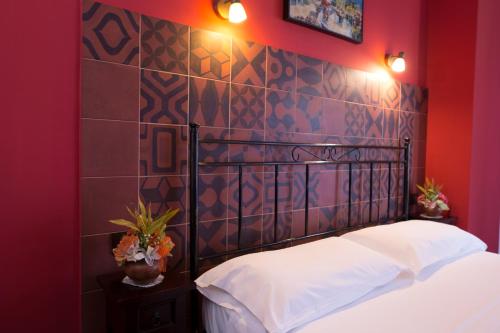 a bedroom with a bed and a red wall at Le Cinque Novelle in Agrigento