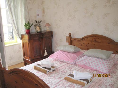 a bedroom with a bed with two dolls on it at Hotel Le Commerce in Neuville