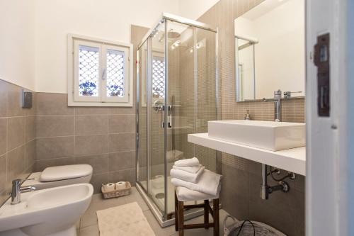 a bathroom with a sink and a toilet and a shower at Fiore Penthouse in Alghero