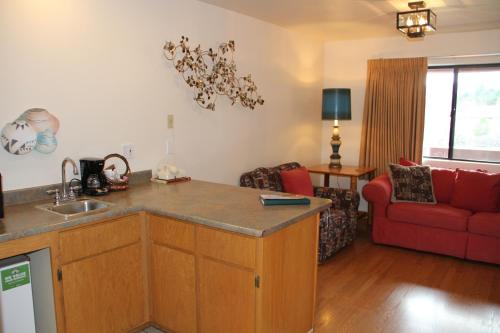 a kitchen and living room with a red couch at Sedona Village Lodge in Sedona