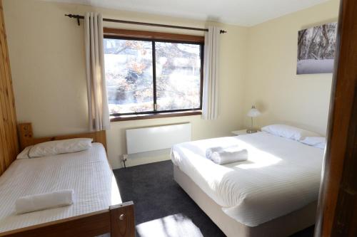 a bedroom with two beds and a window at Leski Club in Jindabyne