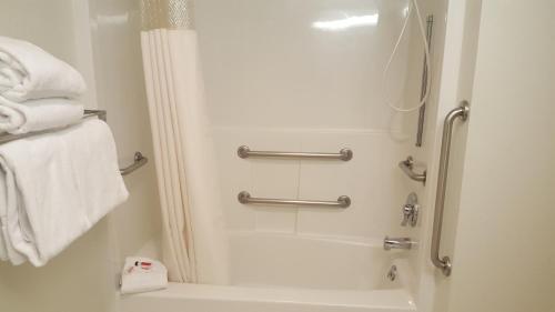 a bathroom with a shower and a bath tub with towels at Baymont by Wyndham Coeur D Alene in Coeur d'Alene