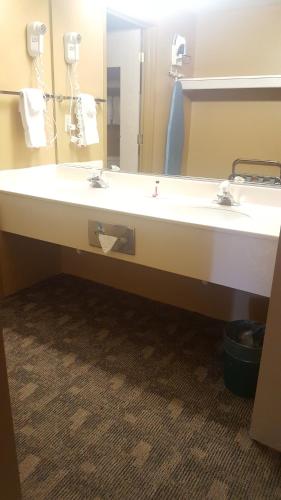 a bathroom with a large white sink and a mirror at Baymont by Wyndham Coeur D Alene in Coeur d'Alene
