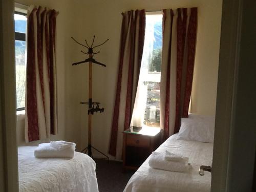 a hotel room with two beds and a window at River Terrace Cottage in Motueka