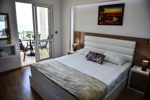 a bedroom with a large bed and a balcony at Villa Premier in Ulcinj