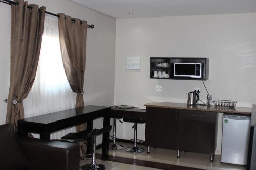 a room with a desk and a microwave in a room at Alcazaba Hotel in Johannesburg