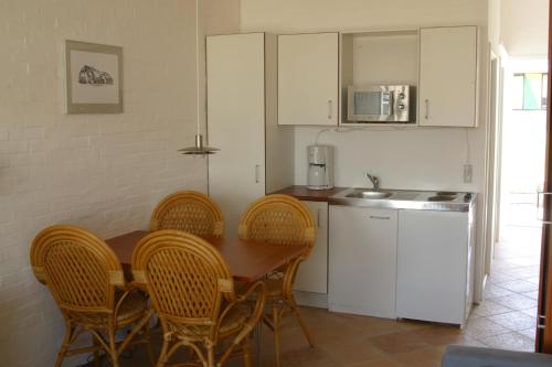 een keuken met een tafel en stoelen en een keuken met een wastafel bij Hotel Lakolk in Rømø Kirkeby